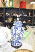 A Chinese style table lamp in baluster form, hand coloured with blue floral patterns on a white