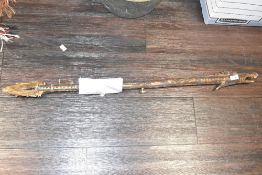 A 20th century carved Indonesian blowpipe with dragon head and serpentine carvings. Comes apart in