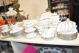 A Wedgwood bone china dinner service decorated with gilt edging, to include plates, cups, gravy jug,