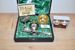 A vintage condiment set, having gilded interiors, to include salt spoons, pepperettes, a pair of