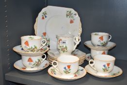 A vintage Pheomix china part tea service hand coloured in the art deco style with orange edging