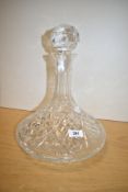 A cut crystal ships decanter, the large bulbous base joining a narrow neck with crystal ball