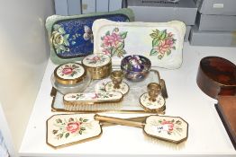 A vintage vanity set decorated having floral patterns with matching candlestick, to include two
