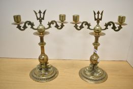 A pair of brass turned candlesticks with trident top and a trio Koi fish base, h27.5cm