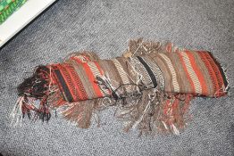 A large Moroccain style woven bad decorated with geometric red and brown patterns, L75cm