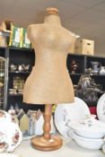 A half body female hessian covered mannequin supported on an oak stand, h72cm