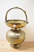 An early 20th century Indian Kamandalu brass holy water carrier having loop handle, engraved with