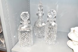 A set of three crystal cut decanters with stoppers, largest h31cm
