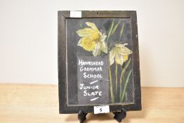 A early 20th century oil painting on slate depicting daffodils, inscribed Hawkshead Grammar