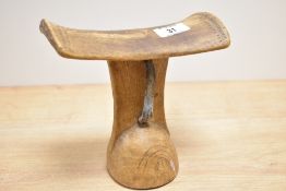 A tribal Ethiopian Gurage headrest having a curved top with carved geometrical patterns and bands of