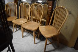 A set of four hoop and stick back wide seat dining chairs