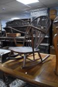 A dark stained Ercol rocking chair having fluer de lys style back