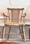 An early 20th Century arm chair having bergere back and turned frame