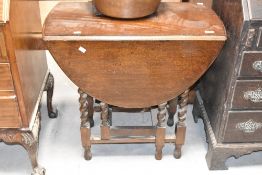 An early to mid 20th Century oak gateleg dining table, width approx. 77cm