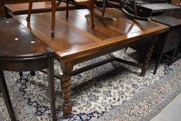An early to mid 20th Century oak drawer leaf dining table having twist legs, approx. 153 ( plus