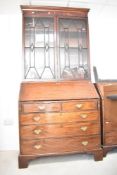 A Georgian and later mahogany bureau having matched astral glazed bookcase over