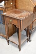 An early 20th Century compact hall table, with drop flaps, labelled for Waring & Gillow, approx.