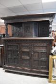 A large and impressive 18th Century oak court cupboard, profusely later carved and bearing date