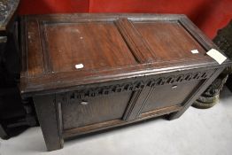 A period oak coffee of small proportions, having two panels and carved frieze, width approx. 87cm