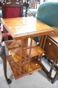 A reproduction yew wood revolving bookcase