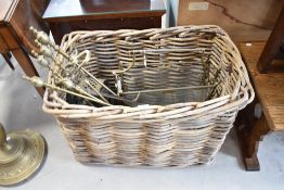 A large vintage basket and selection of antiques brasswares including paper rack and fire tools etc