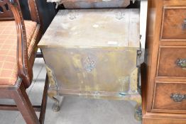 An antique brass coal or kindling box having fleur de lys style applique decoration