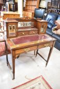 A Victorian ladies writing desk having inlaid lute and cherub decoration and later leather inset