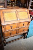 An early 20th Century oak bureau on bulbous supports and style frame