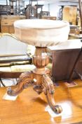 A Victorian mahogany piano stool having turned support and triple scroll feet