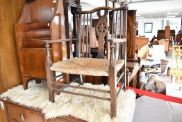 A 19th Century spindle back carver chair having low rush seat