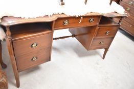 An early to mid 20th Century mahogany desk or dressing table having shaped front, lock stamped IWS