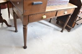 An early 20th Century office desk having two drawers and turned legs