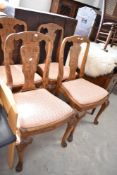 A set of four early to mid 20th Century walnut dining chairs having vase backs and drop in seats