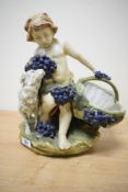 A Capodimonte style figure depicting a young boy with basket having blue berry decoration,