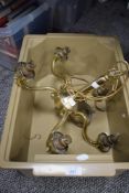 A modern brass five arm light fitting in need of shades.
