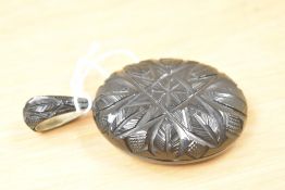A large carved jet locket, having intricate linework carving to the front and pendant loop.