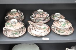 A group of four Chinese porcelain lidded soup bowls, along with five spoons, having decorative green