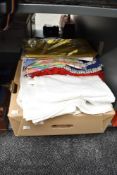 A box containing various linen table cloths