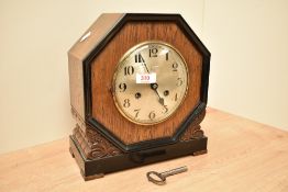 A 1930's/40's oak and ebonised wood mantel clock, of octagonal form with carved base 'brackets'