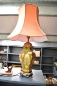 A ceramic lamp of baluster form having orange shade, decorated with stylised floral patterns on a