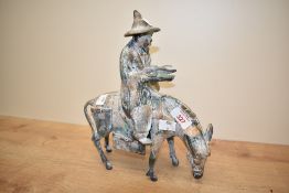 A Japanese 'toyo' cast metal figure of a gentleman on horse back, roughly cast with gilt paint and