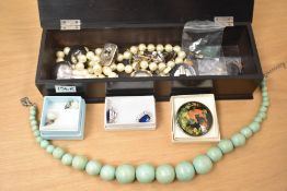 An ebonised wooden jewellery box, containing a small collection of costume jewellery, including