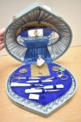 A vintage cased musical manicure set, having vanity mirror in lid, blue lined interior and dancing