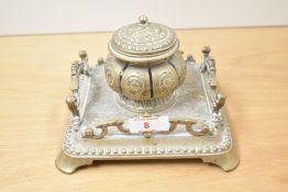 A 19th century brass inkwell with central lidded ink holder, decorated with ornate floral