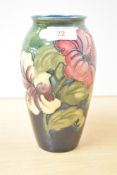A Moorcroft pottery Hibiscus pattern vase of ovoid form with blossoms on a green ground, paper label
