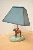 A vintage lamp, having a stained white stone green old painted metal huntsman on horse, 36cm