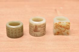 A group of three Chinese greenstone/jade/nephrite archers rings, two having inscribed text, one with