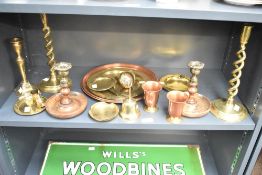 A collection of brassware cups, plates, ashtrays and a pair of twist stem candlesticks and turned