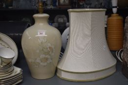 A large ceramic table lamp of baluster form, decorated with floral patterns on a green glaze ground,