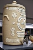 A Victorian Atkins stoneware water filter, decorated with relief foliage and coat of arms banners on